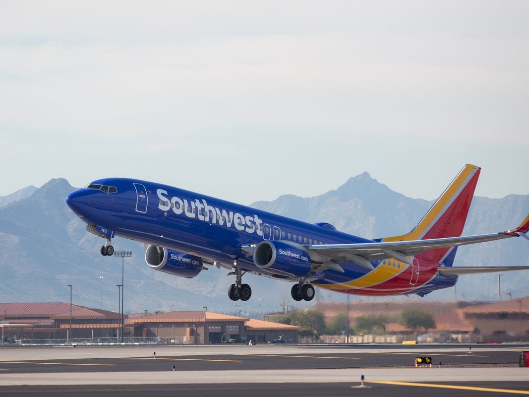 A Southwest Airlines Boeing 737 preparing to land, with mountains in the background